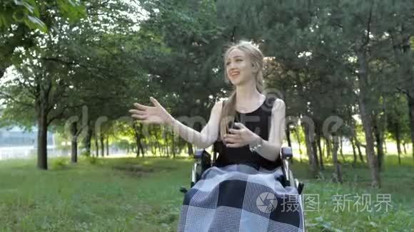 漂亮的金发女孩坐在轮椅上，玩飞盘玩得很开心