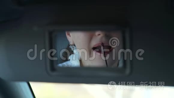 迷人的女人在车镜里的唇彩视频
