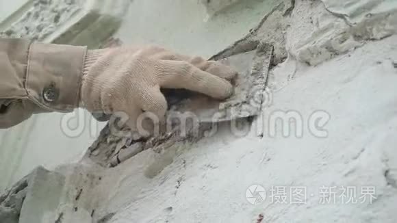 建筑工人`双手用大刀准确地把灰色的墙抹上灰