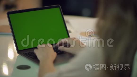 女商人在带绿色屏幕的笔记本电脑上工作