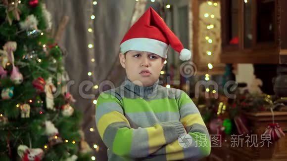 穿毛衣戴圣诞老人帽子的男孩生气了。他没有天赋。在