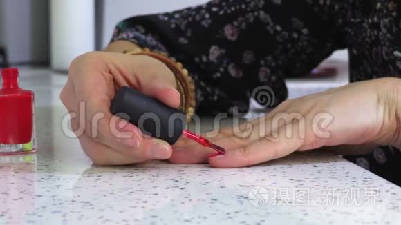 女人把手放在桌子上涂指甲油
