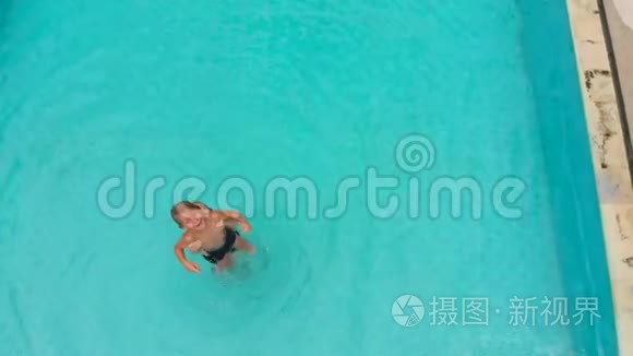 一位年轻女子和她的小儿子在热带地区的游泳池里玩得很开心