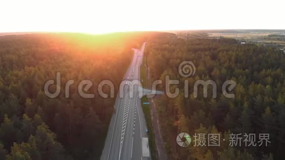 空中日出拍摄城市外的道路在一个乡村森林与卡片和卡车通过购买跟随车辆拍摄