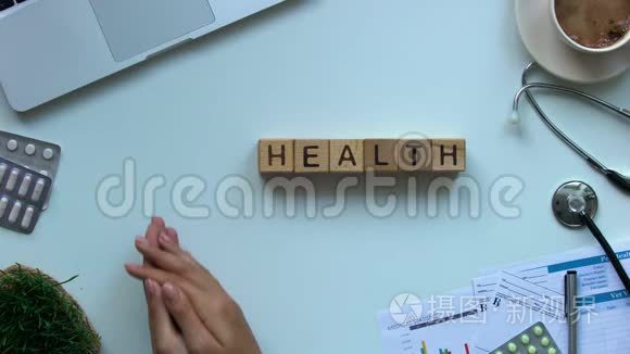 健康单词：桌子上的木立方体，医生拿着玩具心脏，捐献者