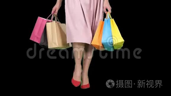 年轻女子双腿背着五颜六色的购物袋，阿尔法频道
