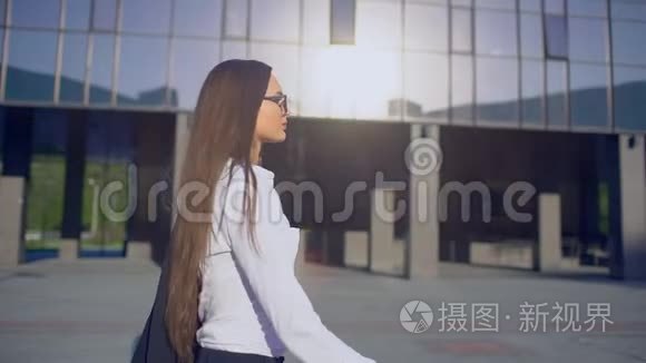 年轻成功女商人或女学生穿着现代西装穿着白色衬衫走在路上的女性的侧视