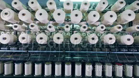 现代纺织工厂机器与线轴与白色纤维。