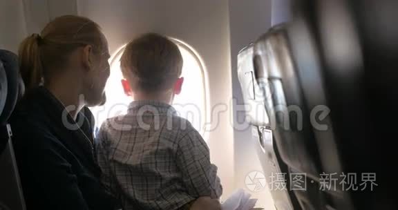 母亲和儿子在飞机上寻找照明器视频