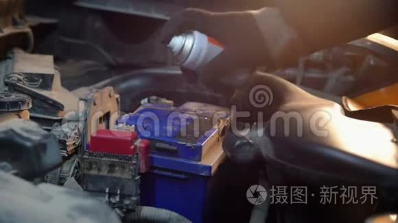 汽车服务。 一个机械师在电池上喷油漆