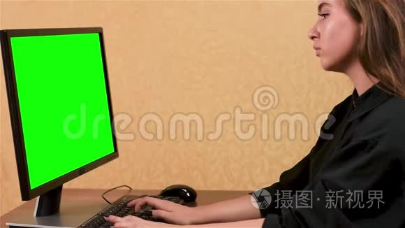 在办公室用电脑工作的女人。 绿色屏幕