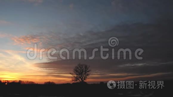 美丽的橙色日落越过白俄罗斯的田野，夕阳和美丽的云彩越过两极。 日落的天空