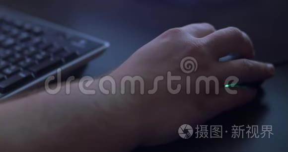 男人在黑暗中用老鼠`手。 玩家晚上玩。 关门