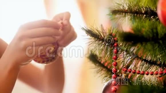 特写4k镜头，年轻女孩用红色和金色的装饰圣诞树