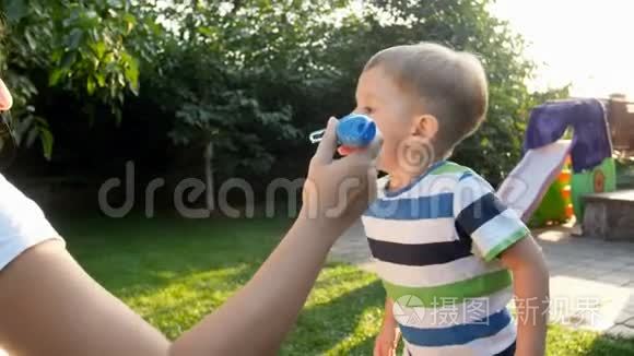 4K小男孩在后院草地上和家人一起吹肥皂泡的镜头