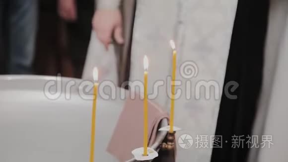 在东正教教堂用燃烧的蜡烛洗礼婴儿的字体。