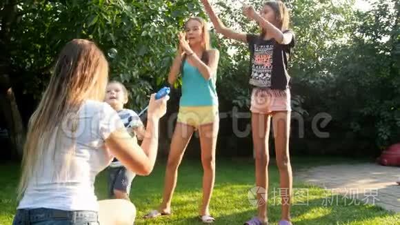 4k视频快乐的家庭在家后院追逐肥皂泡