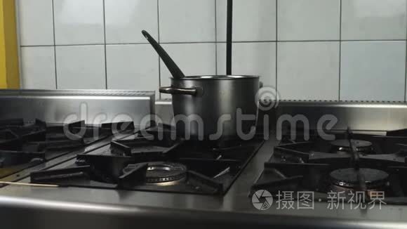 不锈钢锅子放在厨房餐厅或咖啡厅的油腻的肮脏煤气炉上，环境不卫生