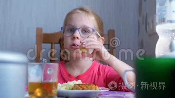 小可爱的小女孩在厨房的桌子上吃一个煮鸡蛋