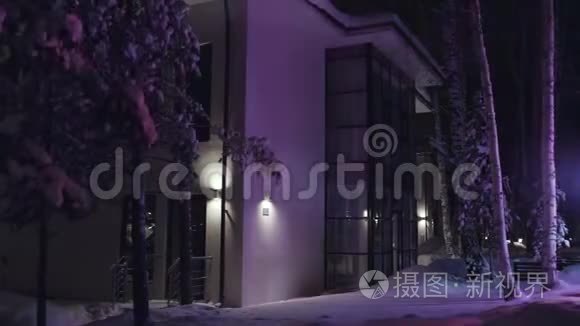 两层乡村小屋侧景，在夜间紫色的微光下，有全景窗