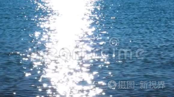 在阳光明媚的夏日，波光粼粼的新鲜波浪水在缓慢的运动中闪闪发光