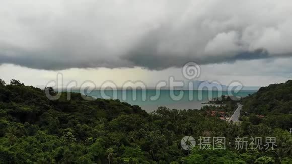 在热带岛屿上空盘旋。 灰色多云的天空，绿色的手掌在苏梅岛潮湿的季节在泰国。 无人机视图