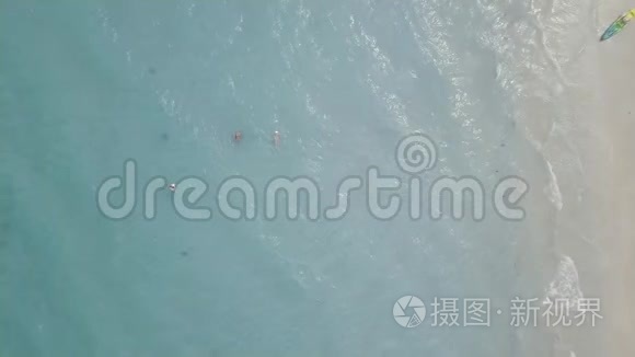 人们在蓝色的大海里游泳，皮艇躺在沙滩上。 从无人驾驶游客的空中俯瞰