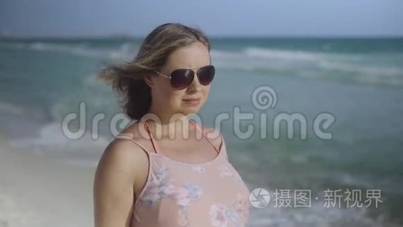 美丽的孕妇走在海边，年轻的女人在等她的孩子，抚摸着他的胃