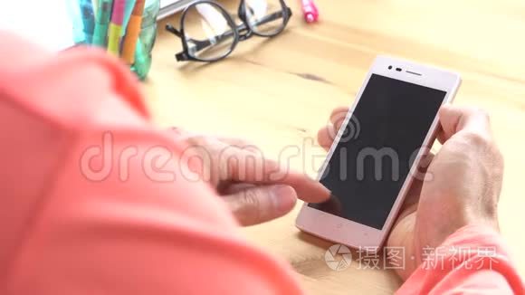玫瑰粉色t恤商人滑动变焦触摸智能手机在家庭办公室