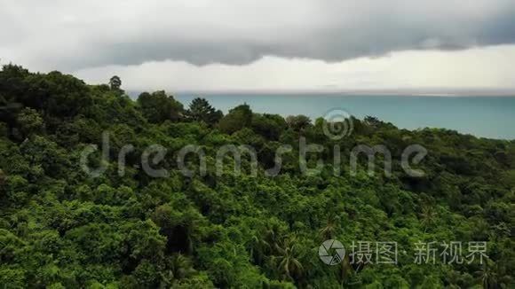 在热带岛屿上空盘旋。 灰色多云的天空，绿色的手掌在苏梅岛潮湿的季节在泰国。 无人机视图