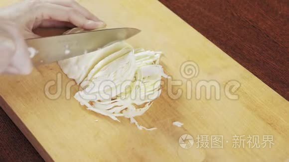 一个女人用刀子在木板上割白菜视频