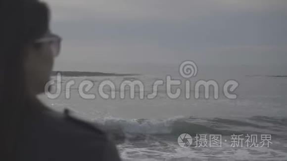 女人望着海浪冲刷沙滩海岸视频