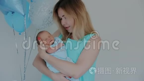 美丽健康的母亲抱着她新生的孩子。 亲吻宝宝