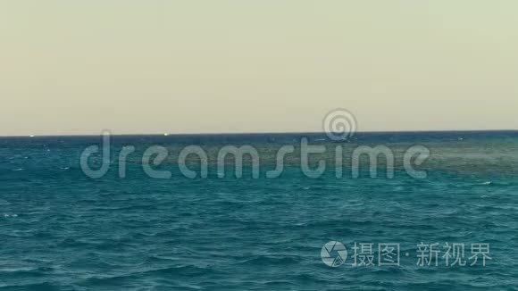 夏天，海景。 水面，宁静平静的绿松石海和蓝天。 度假者带着面具游泳，以便浮潜