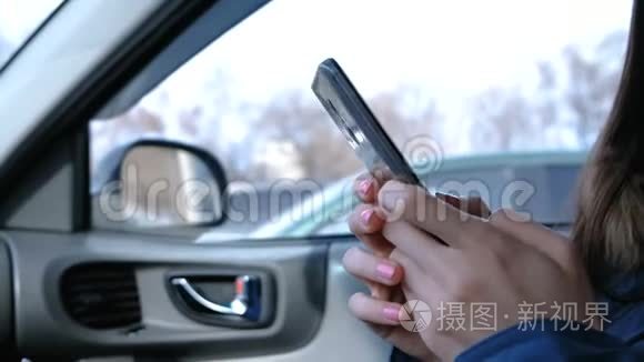 有手机的女人在车里。 特写女人`手在电话里聊天。
