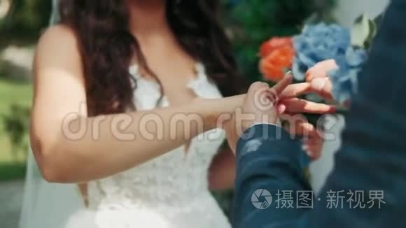 新娘和新郎在绿色自然背景下交换结婚戒指