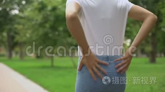 苗条的女人在公园散步，感觉背痛不适，风湿，保健