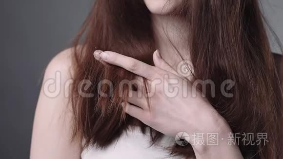 女人手里拿着她干脆的头发,头发护理,洗发水和化妆品,用于强壮的头发