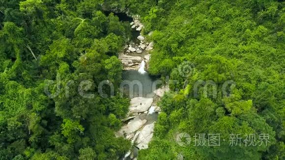 热带瀑布流经热带森林雄蜂景观。空中拍摄的热带瀑布和绿色山湖