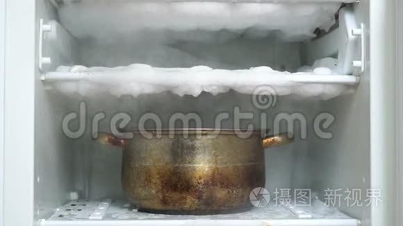 用盛满热水的厨房大锅解冻冰箱视频