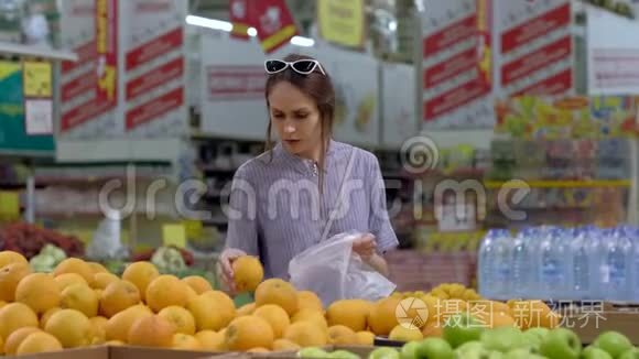 一位年轻女子在超市买橘子
