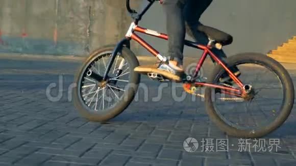 青少年在BMX自行车上玩把戏，慢动作。