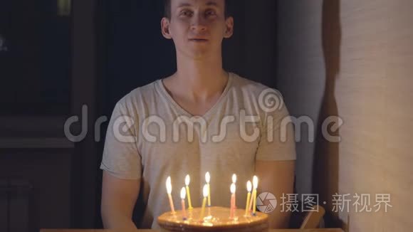 年轻人在节日蛋糕上吹蜡烛视频
