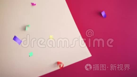 在粉红色背景上飞舞的纸屑视频