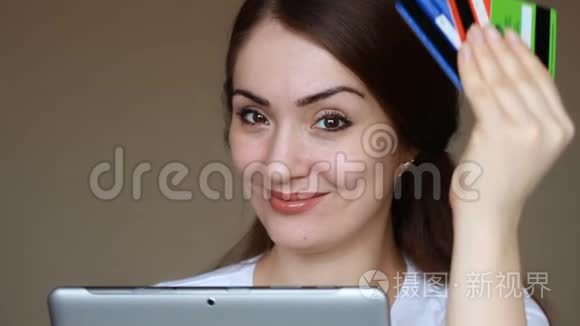 年轻妇女使用平板电脑进行网上银行，在网上商店购物，并通过信用卡购买