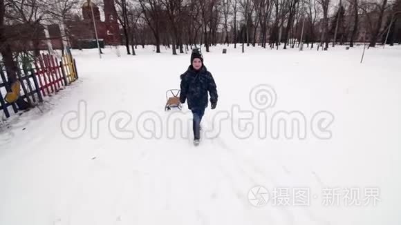 一个带雪橇走路的小男孩被视频