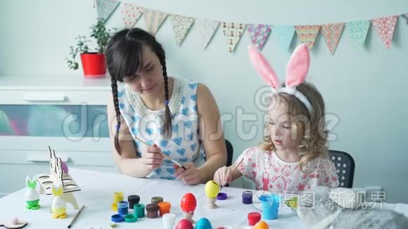 小女孩和妈妈一起装饰复活节彩蛋