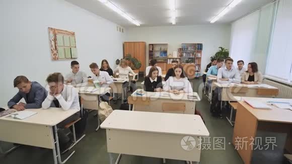 课前，教室里的学生坐在课桌前。 俄罗斯学校。