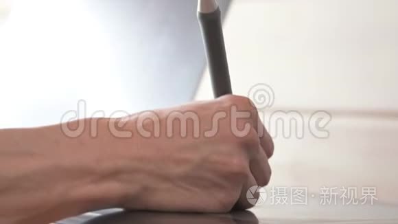 一位男性设计师的特写镜头借助他的笔记本电脑。 平板电脑和笔笔