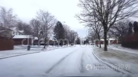 在有运动模糊效应的日子里驾驶覆盖雪的住宅郊区街